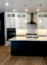 A modern kitchen featuring white cabinetry and a large island.
