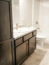 Dark stain custom bathroom cabinets with white laminate countertops and gray hexagon vinyl flooring