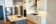 White Kitchen with Grey Island, Herringbone Pattern Subway Tile Backsplash and Vent Hood
