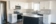White Kitchen Cabinets with Grey Island, Marble Pattern Laminate Countertops and Grey Subway Tile Backsplash