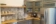 Office Kitchen with tile backsplash, grey cabinets, butcher block countertops and floating shelves